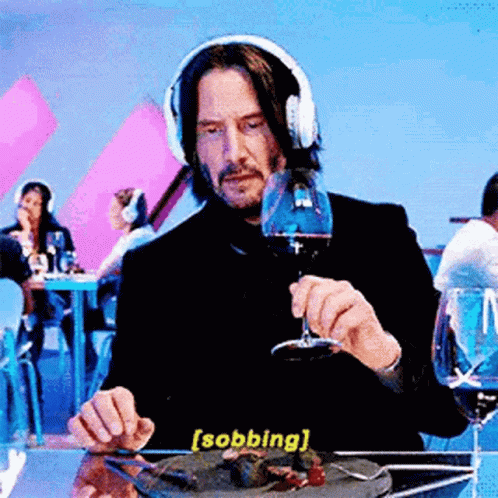 Man In Headphones Sitting At Table With Food And Wine GIF