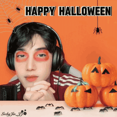 Man In Headphones Surrounded By Pumpkins And Spiders Saying Happy Halloween GIF