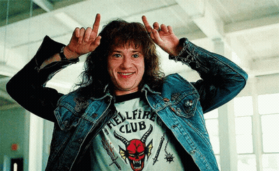 Man in Hellfire Club Shirt Making Horn Sign