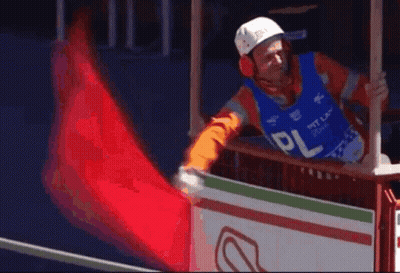 Man In Helmet And Ear Muffs Holding Red Flag With PL GIF