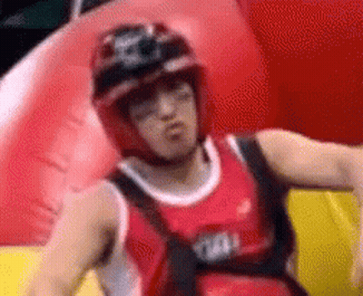 Man In Helmet And Red Tank Top On Red Inflatable Raft GIF