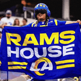 Man In Helmet Holding Blue Rams Flag GIF