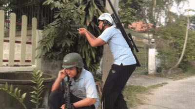 Man In Helmet Holding Gun With Another Man Looking On GIF