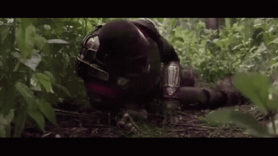 Man In Helmet Laying In Woods GIF
