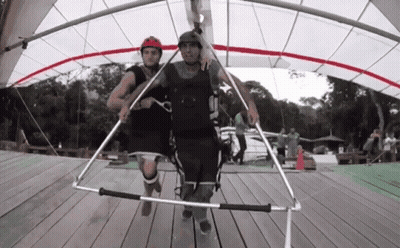 Man In Helmet Number 5 Pulled By Another Man GIF