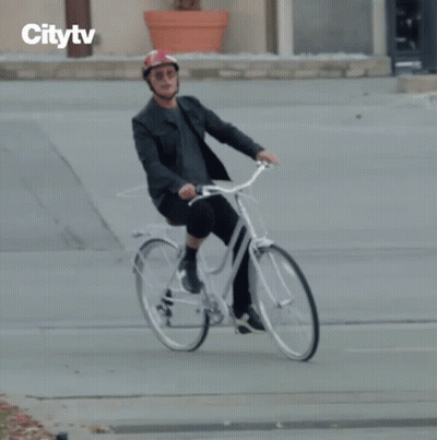 Man In Helmet Riding Bike With Citytv Logo GIF