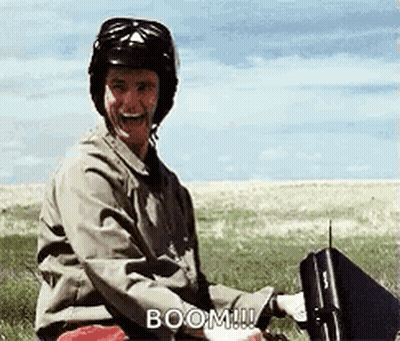 Man In Helmet Sitting In Field Holding Briefcase Laughing GIF