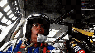 Man In Helmet Sitting In Race Car Talking Into Microphone GIF