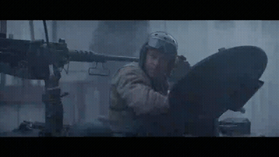 Man In Helmet Standing In Front Of Machine Gun In Dark Room GIF
