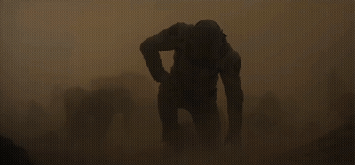 Man In Helmet Walking Through Sandstorm GIF