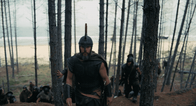 Man In Helmet With Spear Walking Through Forest GIF