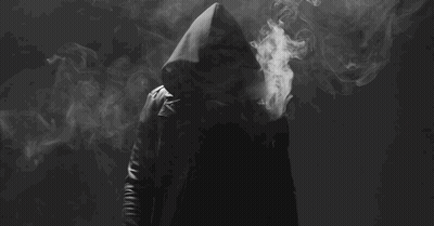 Man In Hood Smoking Electronic Cigarette In Dark GIF