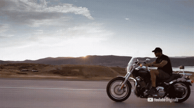 Man In Hooded Cape In Field Of Purple Flowers GIF