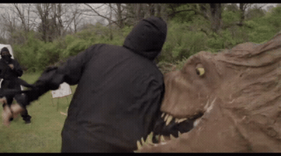 Man In Hooded Jacket Attacked By Dinosaur Statue GIF