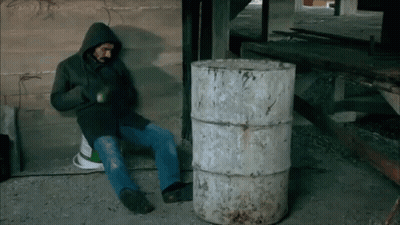 Man In Hooded Jacket By Barrel GIF
