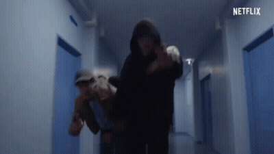 Man In Hooded Jacket Carrying Woman In Hallway GIF