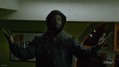 Man In Hooded Jacket In Front Of New York Sign GIF