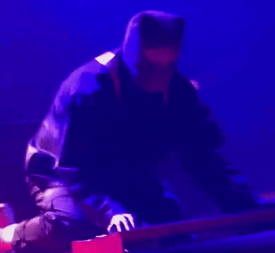 Man In Hooded Jacket Playing Guitar On Stage GIF
