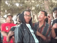 Man In Hooded Jacket Surrounded By Crowd GIF