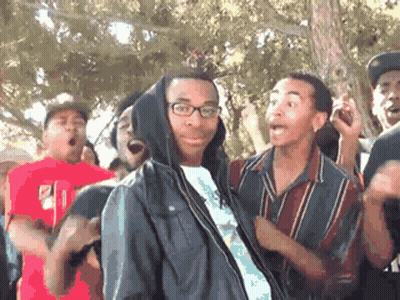 Man In Hooded Jacket Surrounded By Group GIF