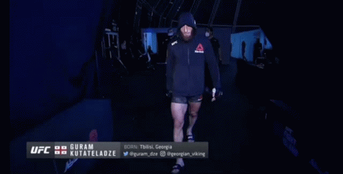 Man In Hooded Jacket Walking Into UFC Room GIF
