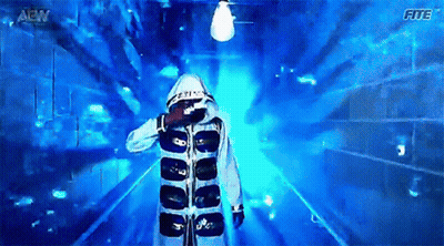 Man in Hooded Jacket Walking Through Blue Tunnel With Letters AEW