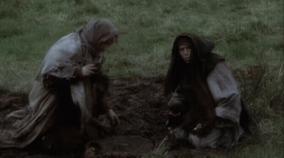 Man In Hooded Robe Kneeling In Grass GIF