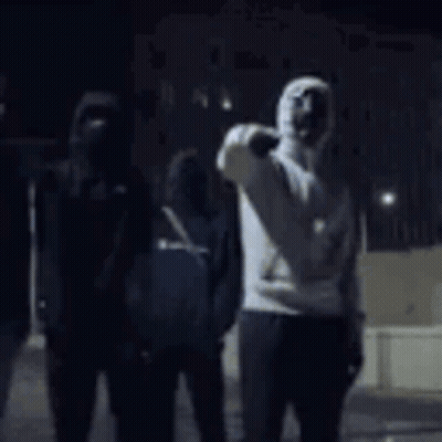 Man In Hooded Sweatshirt Standing In Dark Room GIF