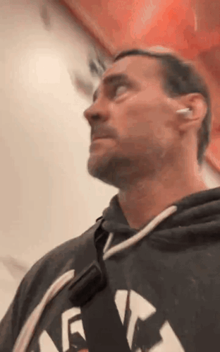 Man In Hoodie And Earbuds Looking Up GIF