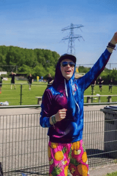Man In Hoodie And Pineapple Shorts In Field GIF