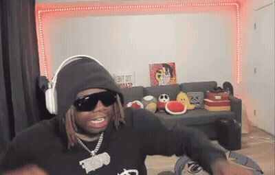 Man In Hoodie And Sunglasses Sitting In Living Room GIF