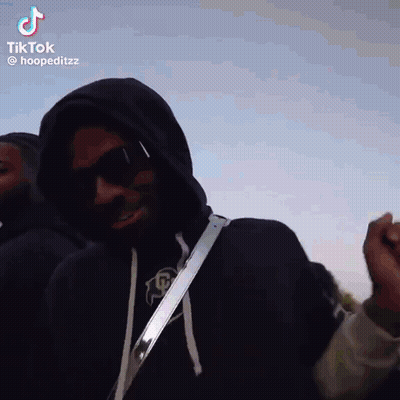 Man In Hoodie And Sunglasses Standing In Front Of Group GIF