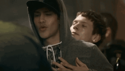 Man In Hoodie Held By Man In Plaid Shirt GIF