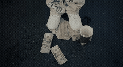 Man In Hoodie Holding Water Bottle In Front Of Motel GIF