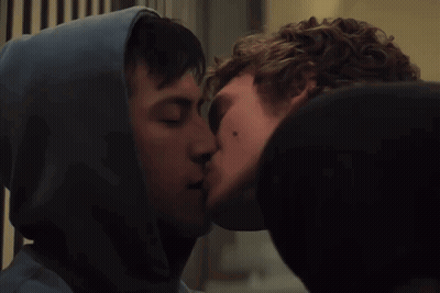 Man In Hoodie Kissing Another Man On Cheek GIF