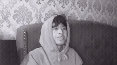 Man In Hoodie Sitting On Couch GIF