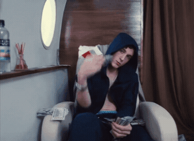 Man in Hoodie Sitting With Aquafina Water