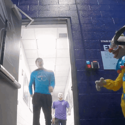 Man In Hornets Shirt Walking Next To Clown GIF