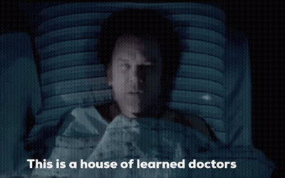 Man In Hospital Bed With Learned Doctors GIF