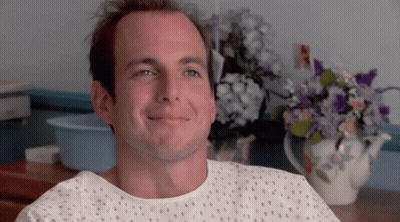 Man In Hospital Gown Smiling Beside Flowers GIF