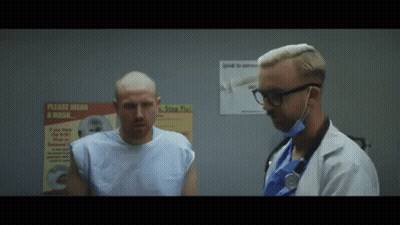 Man In Hospital Gown Talking To Doctor Beside Wear A Mask Poster GIF