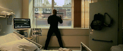 Man In Hospital Room Looking Out Window With Optimum GIF