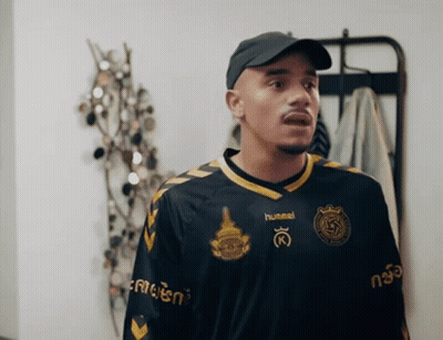 Man In Hummel Jersey In Front Of Clothes Rack GIF