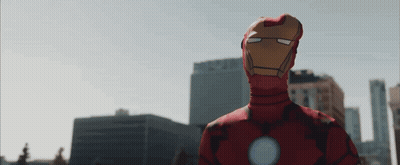 Man In Iron Man Costume In Front Of City GIF