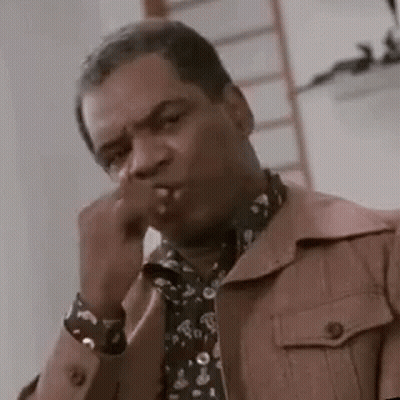 Man In Jacket And Tie Smoking Cigarette Covering Mouth GIF