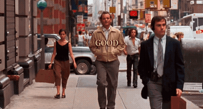 Man In Jacket Saying Good Walking Down Street GIF