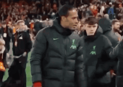 Man In Jacket Walking On Soccer Field With Boy GIF