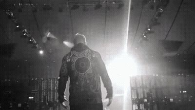 Man In Jacket With Mandala Walking On Stage GIF