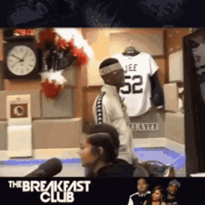 Man In Jeff 52 Jersey Stands In Front Of Clock GIF