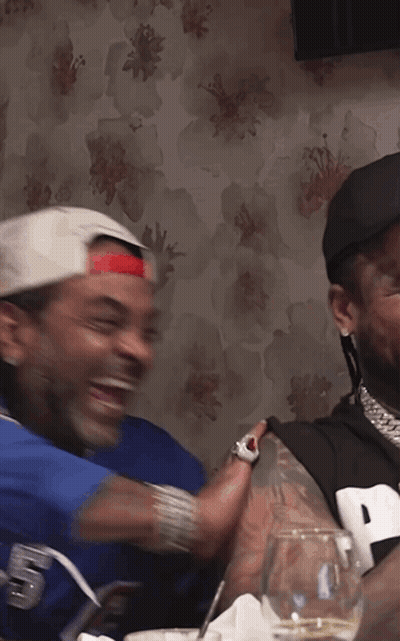 Man In Jersey Number 9 Laughing With Another Man GIF